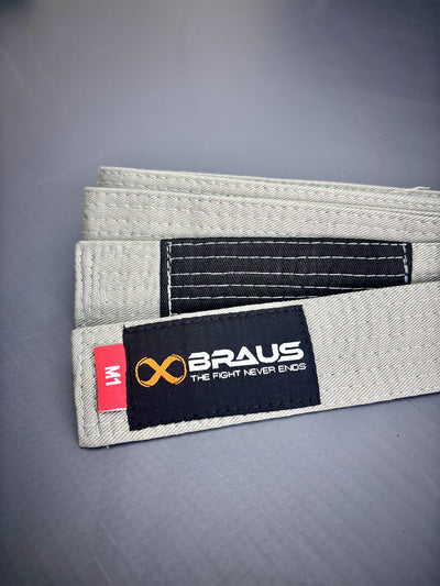 Gray martial arts belt with Braus logo on a gray background
