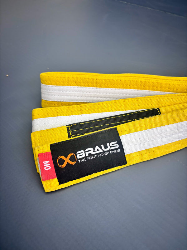 Yellow/White martial arts belt with a label on a gray background