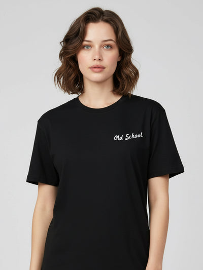 Woman wearing a black t-shirt with 'Old School' text on a plain background