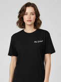 Woman wearing a black t-shirt with 'Old School' text on a plain background