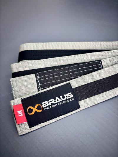 Grey/Black martial arts belt with Braus logo on a gray background