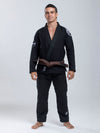 Man wearing a white martial arts uniform with a belt on a gray background