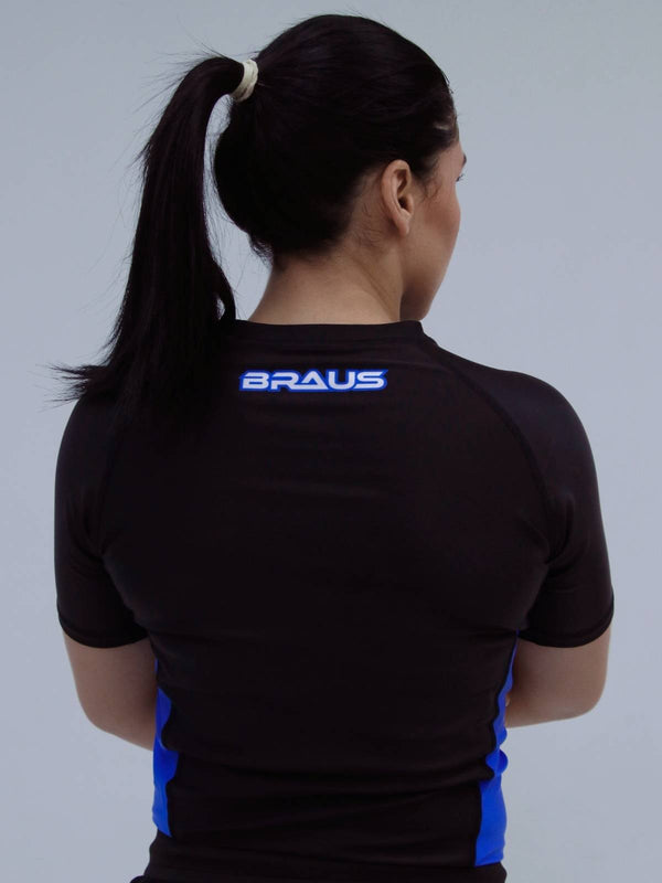Person wearing a blue sports shirt with 'BRAUS' branding on the back against a gray background