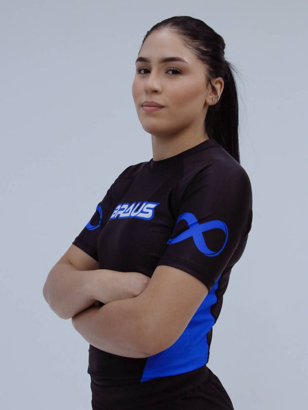 Person wearing a blue sports jersey with a logo on a plain background