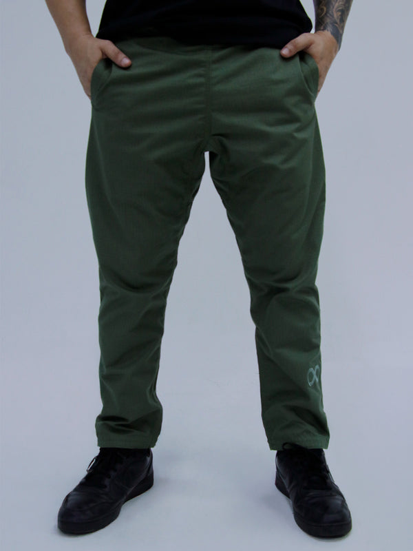 Person wearing army green pants with a brand logo on a plain background