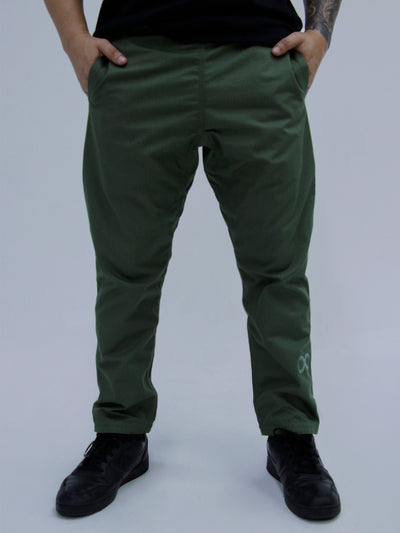 Person wearing army green pants with a brand logo on a plain background