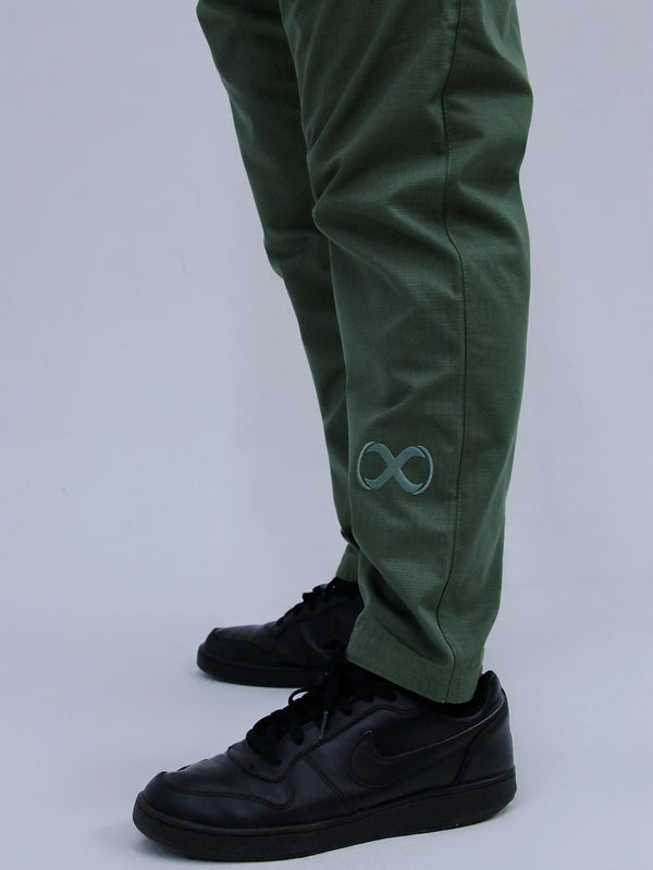 Army green pants with a logo worn by a person on a white background