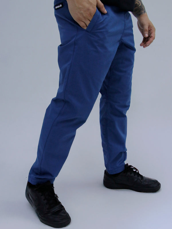 Mid Blue Color  Person wearing blue pants and black shoes on a gray background