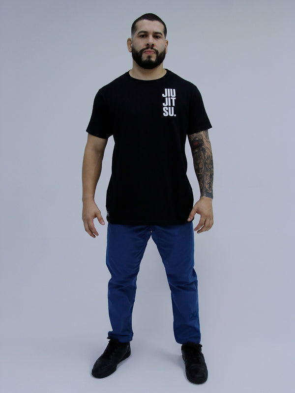 Man wearing a black t-shirt with 'JIU JITSU' text and Mid Blue Color pants on a gray background